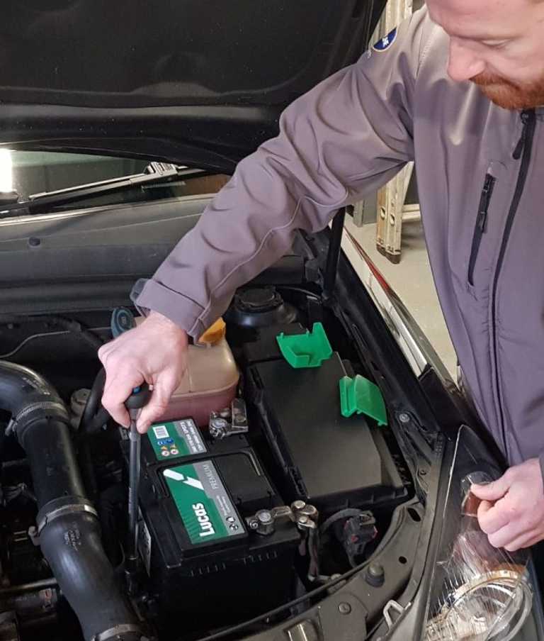 Man fitting car battery