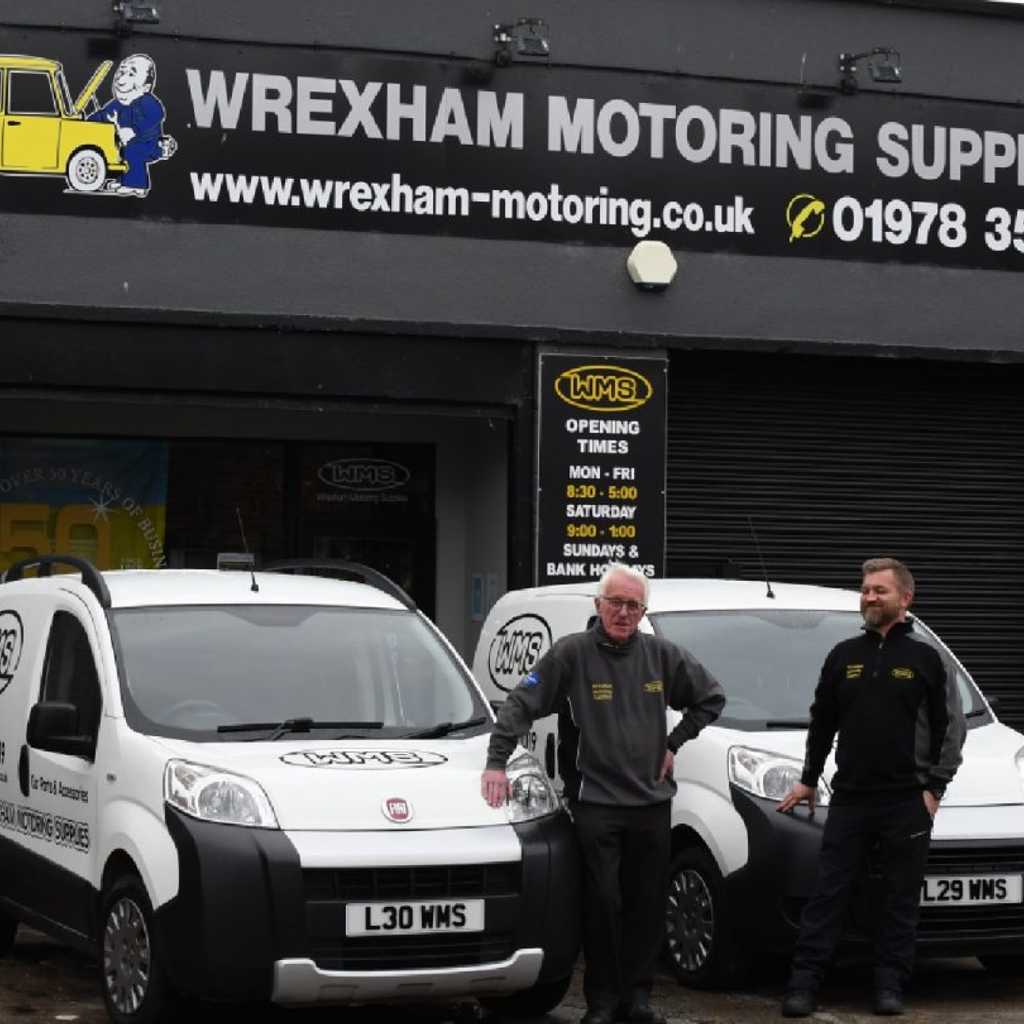 Alun and Jon standing outside of WMS shop next to delivery vans